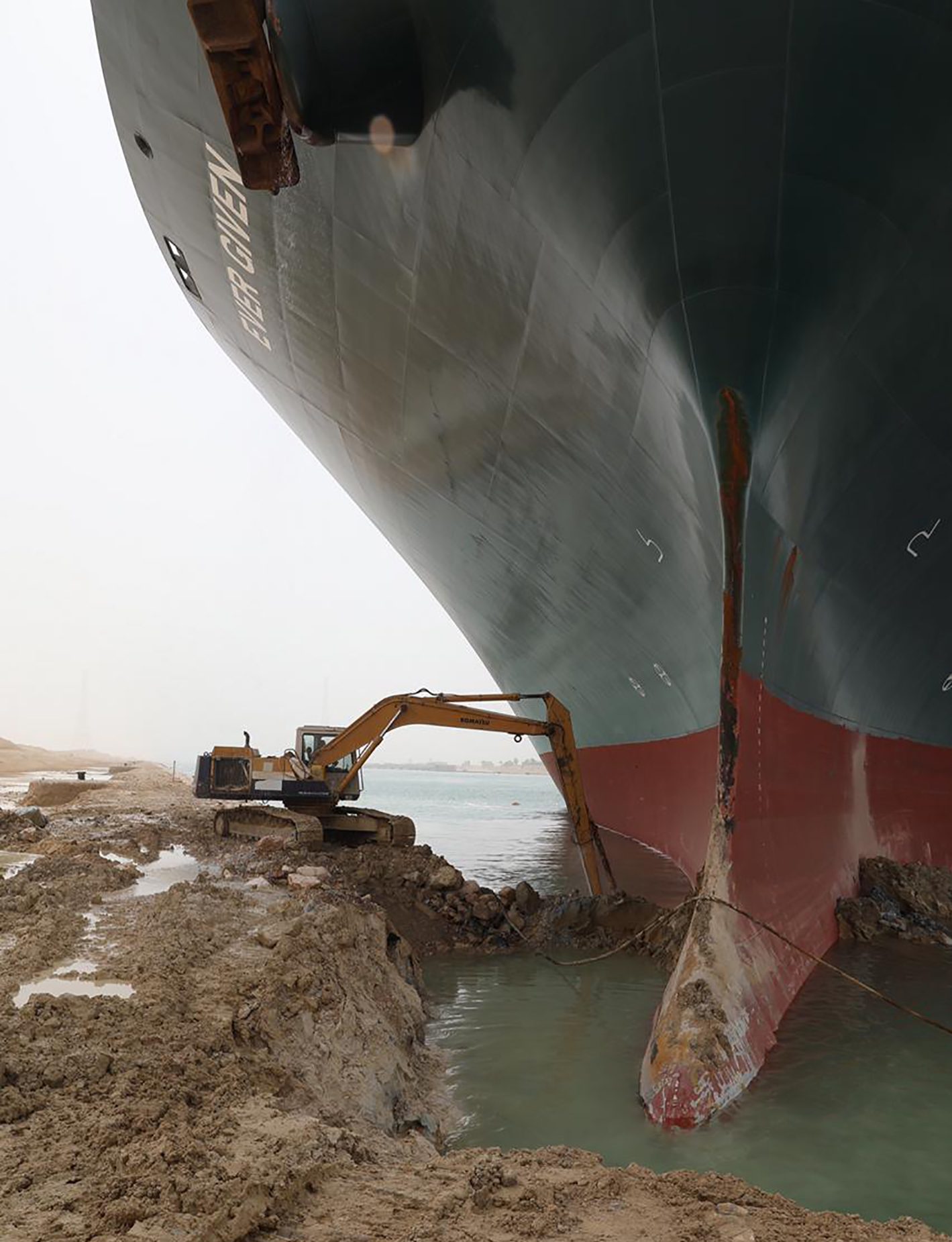A giant container ship being dug out of the sand